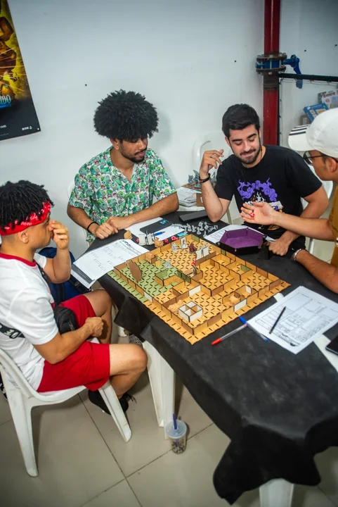 Participantes reunidos em uma mesa de jogos de tabuleiro em 2024.